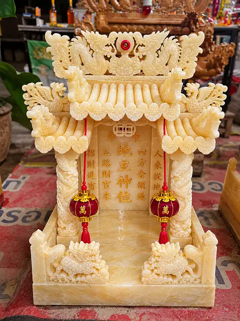Carved marble earth-god shrine with dragons and red lanterns
