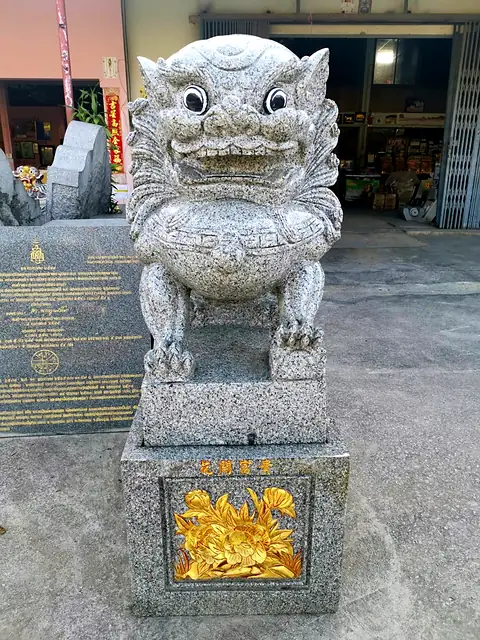Granite lion on a base with gold peony carving